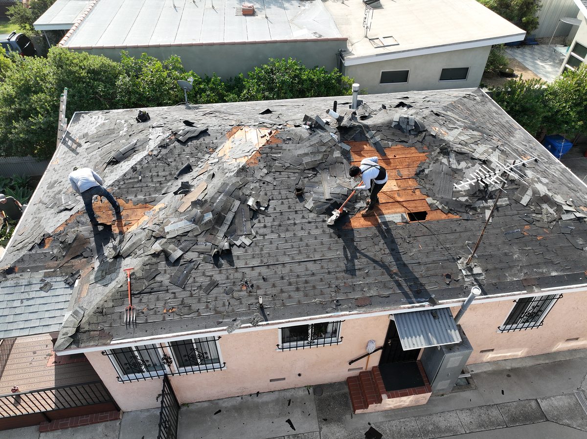 Roof tear-off in progress — old shingles being stripped